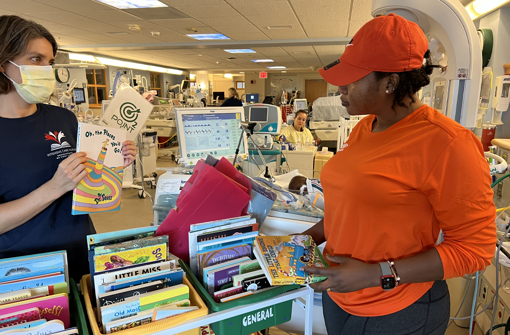 Boura Zerbo stands at the books cart with Books4Brains leader Whitney Zachritz perusing the week’s selection for the perfect choice.